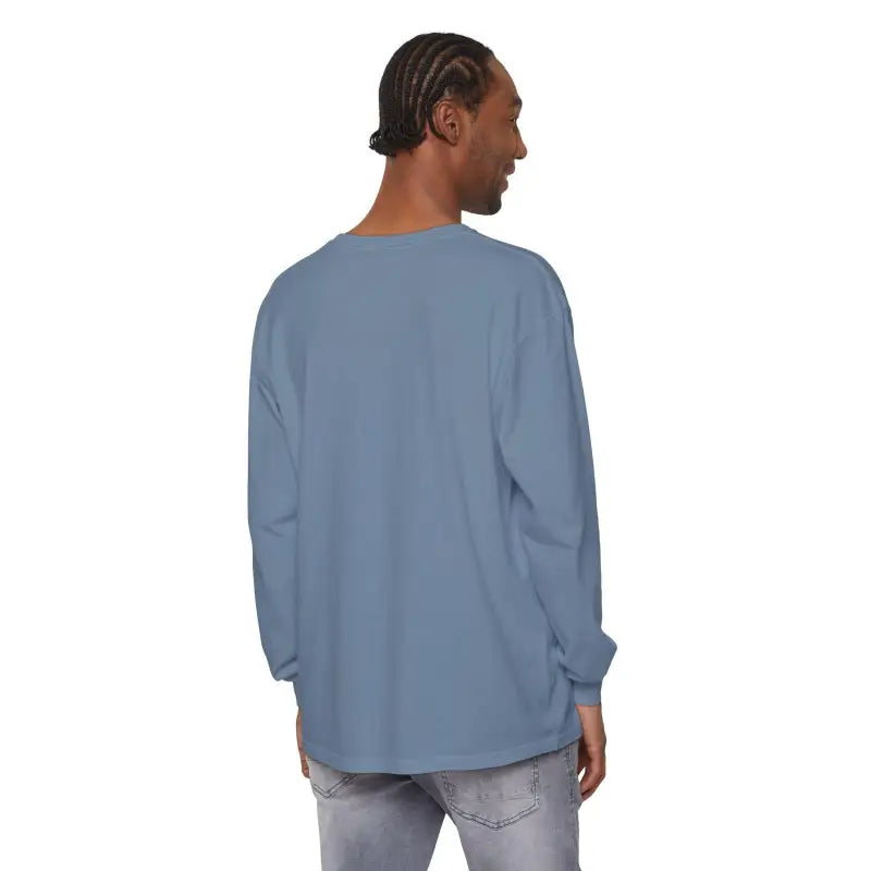 Man in blue long-sleeved shirt featuring Christmas dinosaur and lights design