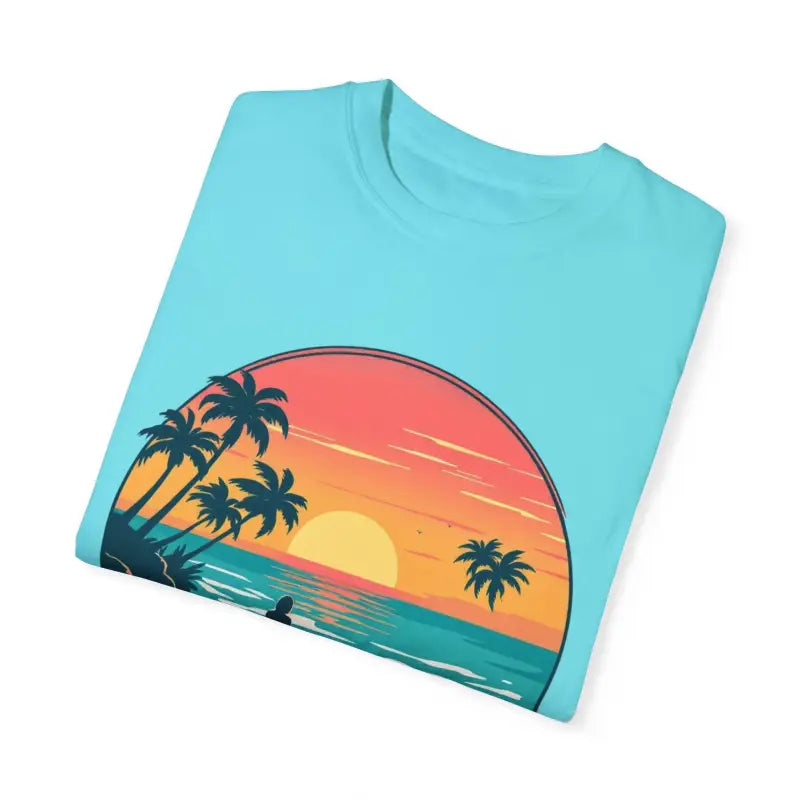 Folded light blue Suns Out Buns Out Unisex T-shirt with beach sunset graphic