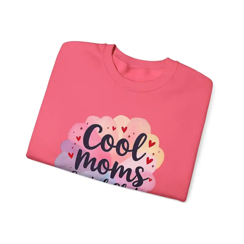 Folded pink t-shirt displayed with Cool Moms Social Club Crewneck Sweatshirt