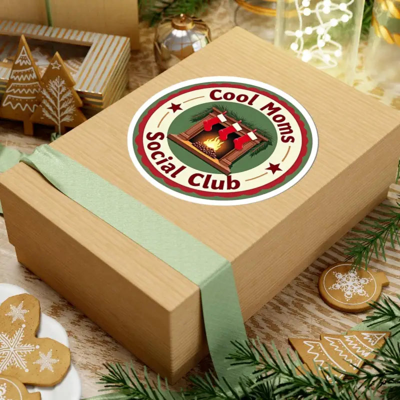 Gift box featuring Cool Moms Social Club sticker with festive fireplace and stockings