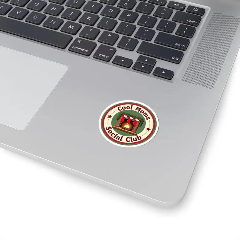 Round Cool Moms Social Club sticker featuring a cozy fireplace and stockings design