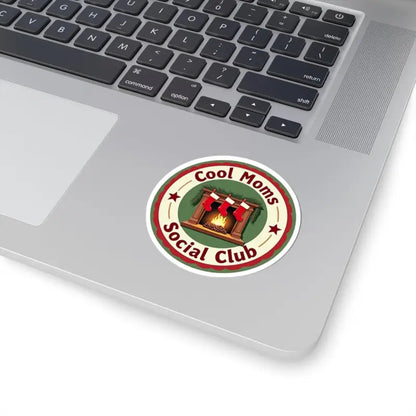 Round sticker featuring a cozy fireplace and stockings for Cool Moms Social Club