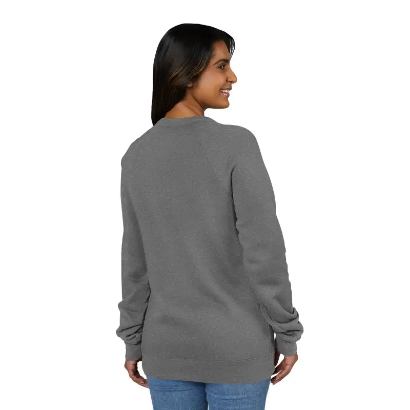 Woman wearing a long-sleeved dark gray crewneck sweatshirt with retro wave graphic and blue jeans
