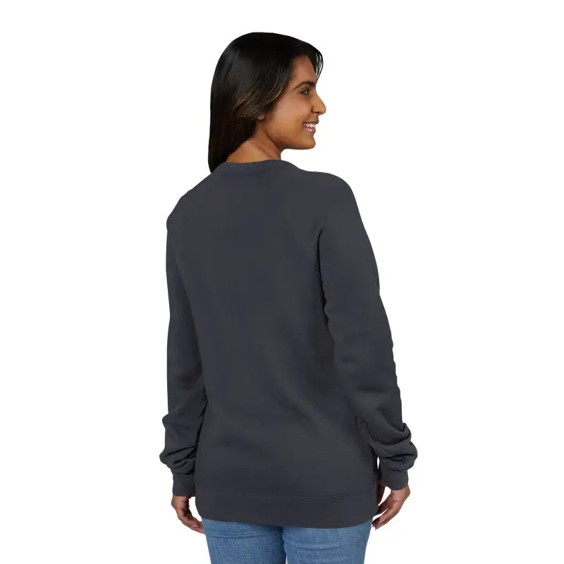 Woman wearing a dark gray crewneck sweatshirt with retro wave graphic and blue jeans