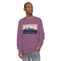 Man wearing a long-sleeved purple T-shirt with mountain and sunset graphic