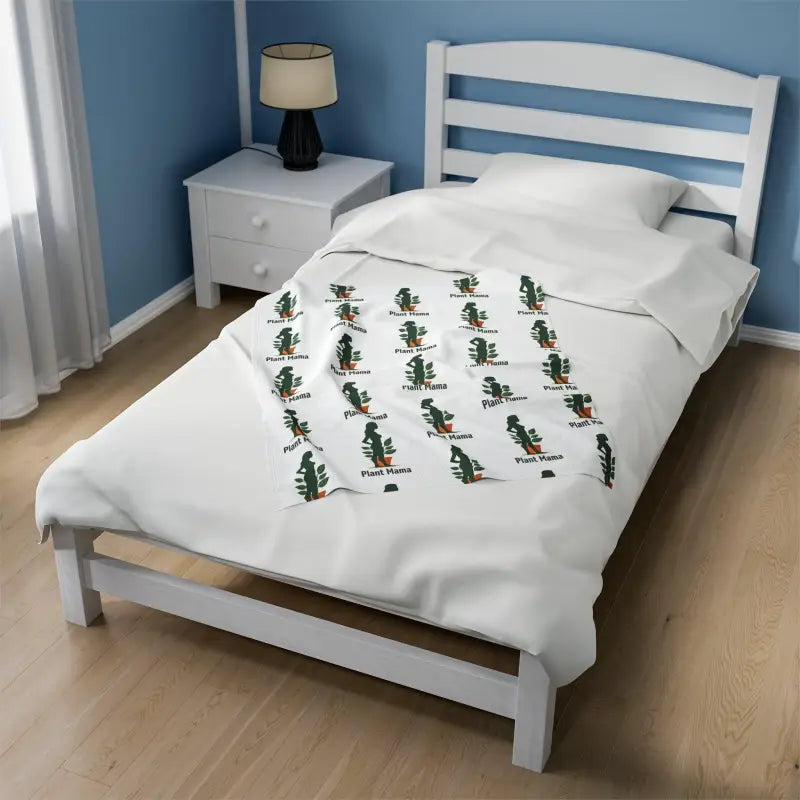 White Velveteen Plush Blanket with Plant Mama Pattern on a white bed with patterned duvet